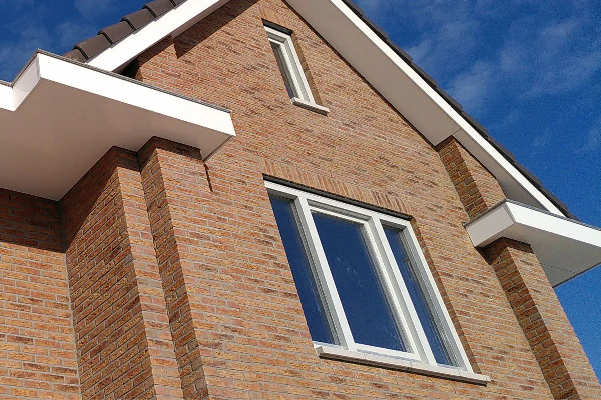 Natuurlijke overstekken boven ramen zorgen voor schaduw in de zomer en zonnewarmte in de winter bij zuidgeoriënteerde nieuwbouwwoning.